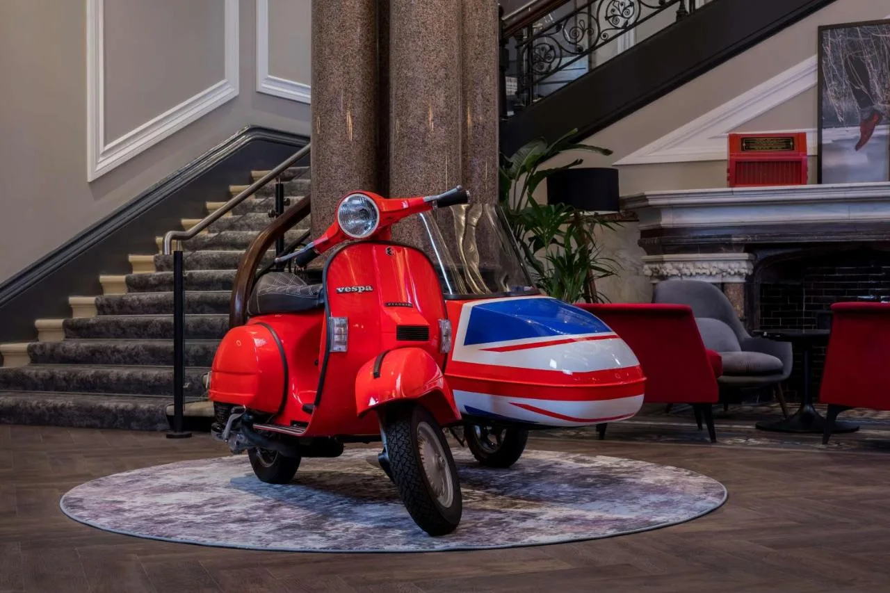 a red scooter parked in a room with stairs at Radisson RED Hotel, Liverpool in Liverpool