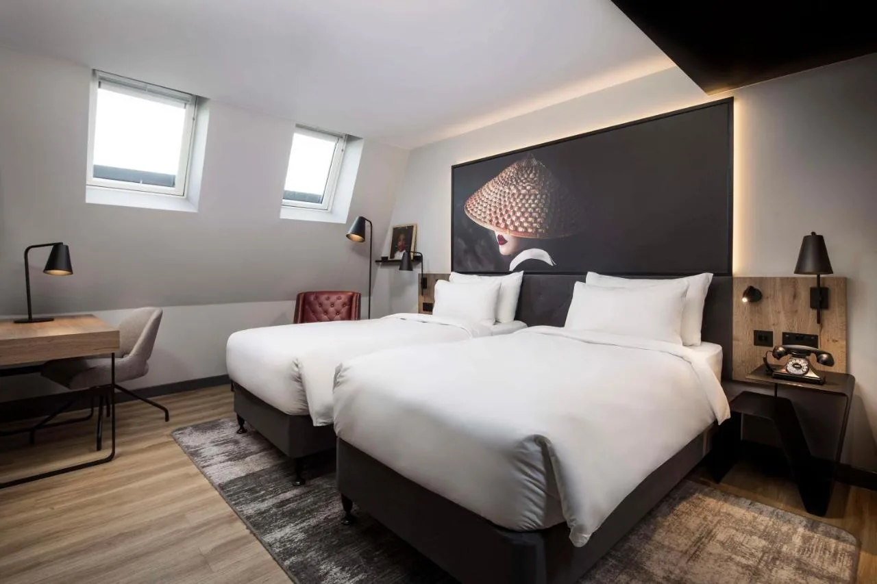 a hotel room with two beds and a desk at Radisson RED Hotel, Liverpool in Liverpool