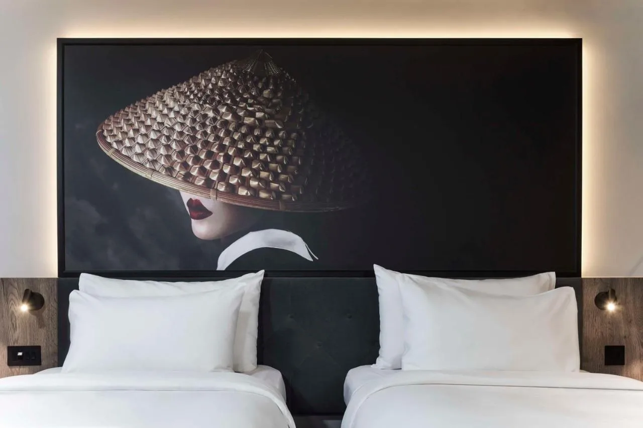 a picture of a woman with a hat above two beds at Radisson RED Hotel, Liverpool in Liverpool