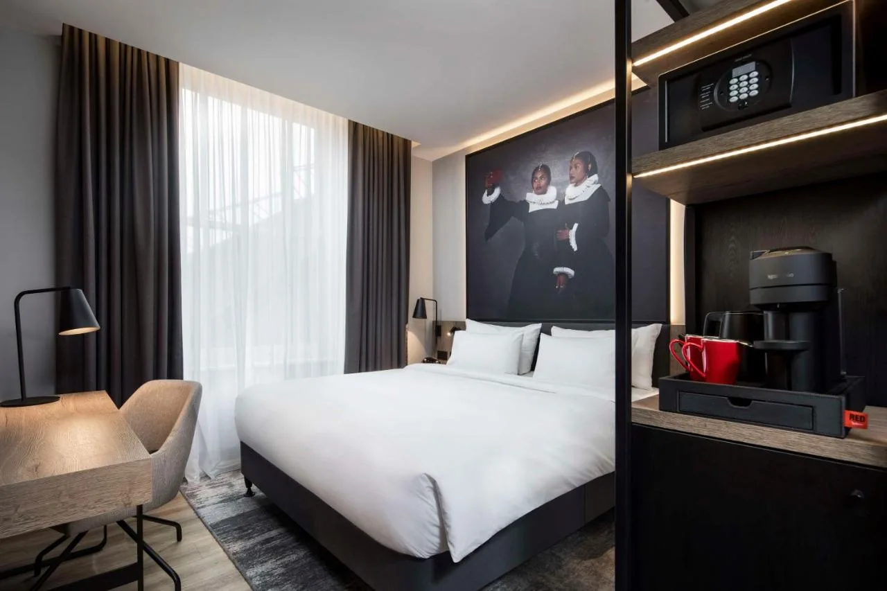 a hotel room with a white bed and a tv at Radisson RED Hotel, Liverpool in Liverpool